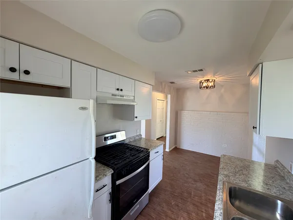 a kitchen with granite countertop a refrigerator and a stove