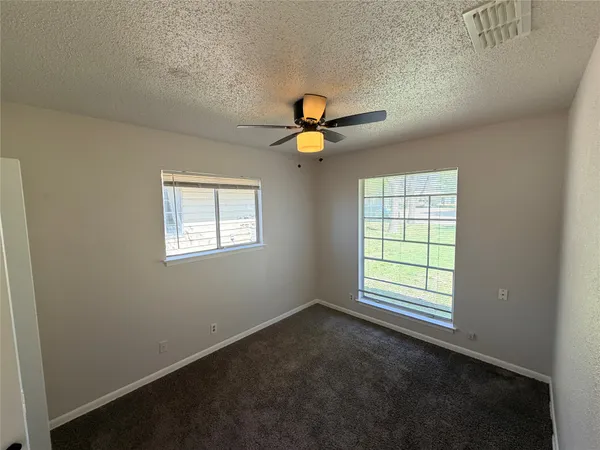 an empty room with closet and windows