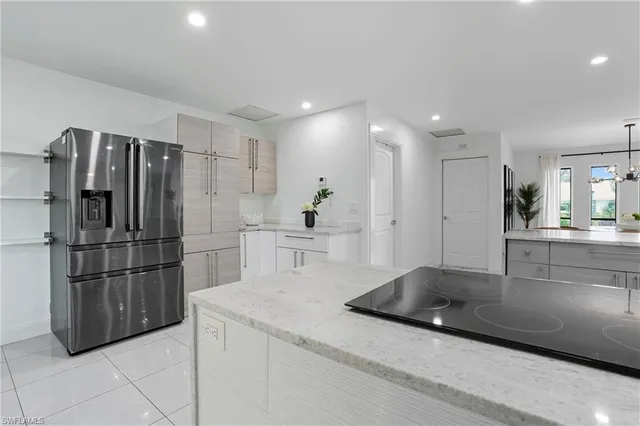 a kitchen with stainless steel appliances kitchen island granite countertop a refrigerator and a sink