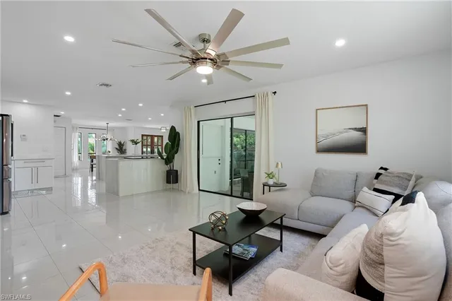 a living room with furniture and a view of kitchen