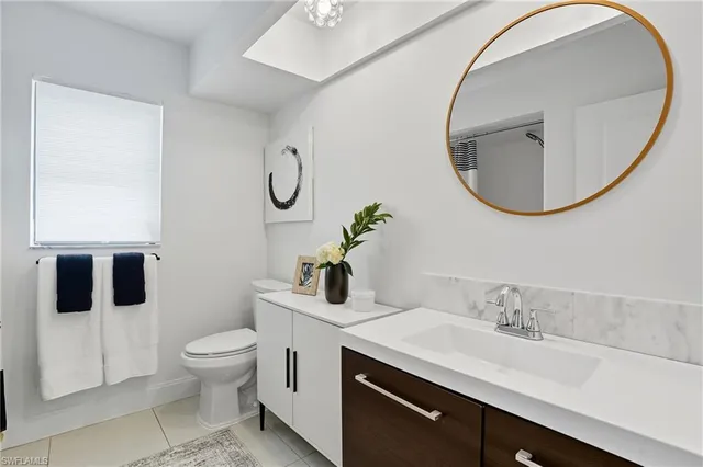 a bathroom with a granite countertop toilet sink and mirror