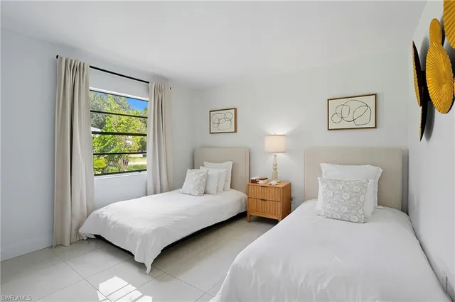 a bedroom with two beds and a window