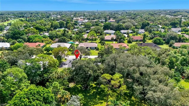 an aerial view of a houses with a yard and lake view