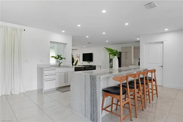 a kitchen with stainless steel appliances kitchen island granite countertop a table and chairs in it