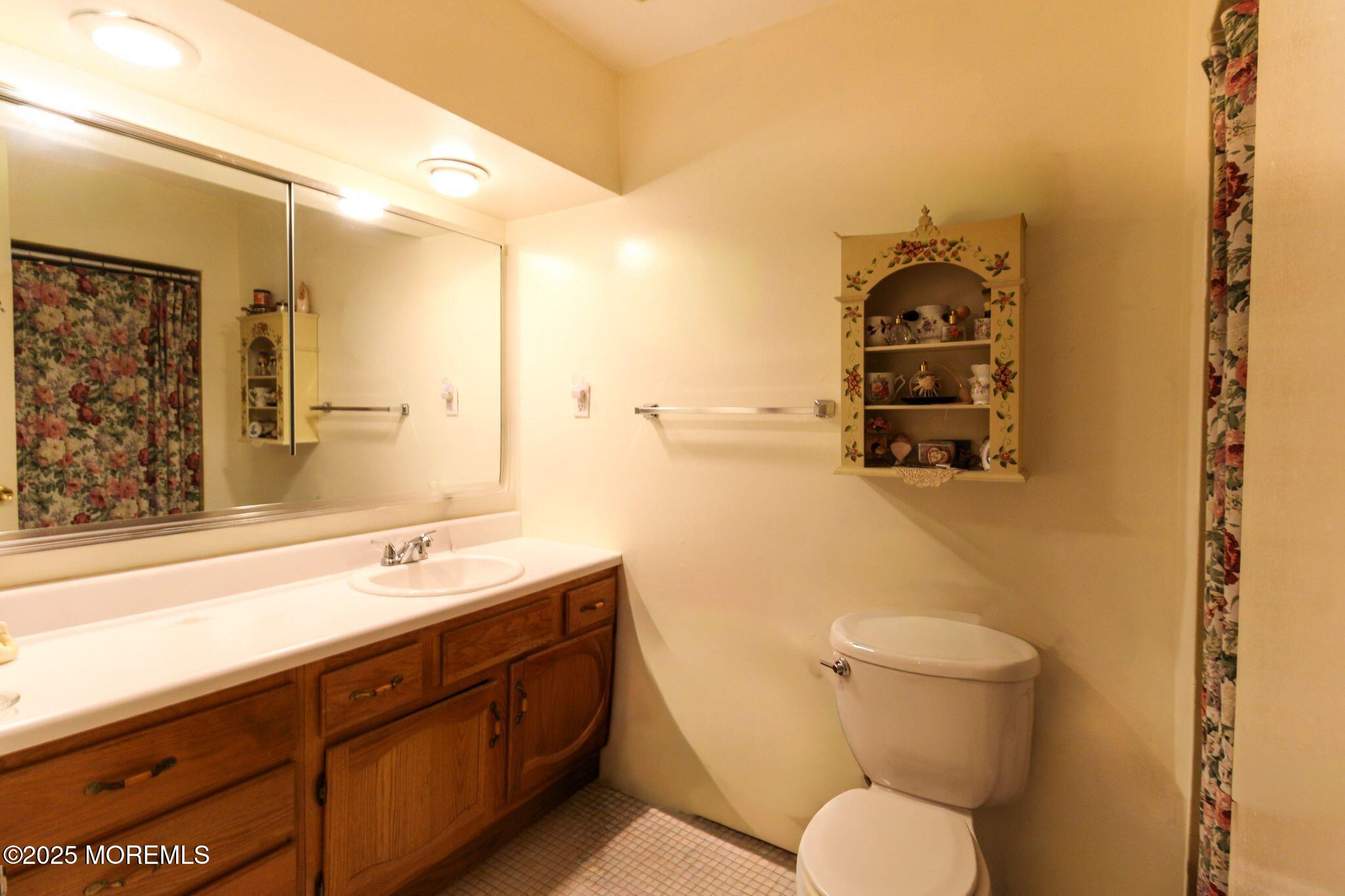 24 Meadow Green Circle, Unit A Manalapan, NJ 07726 - Photo 12 of 24 a bathroom with a toilet sink and mirror