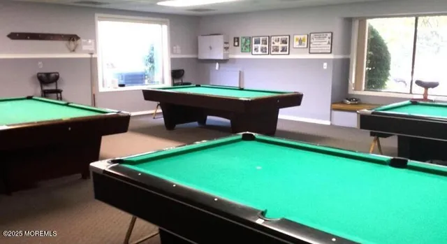 a room with pool table and windows