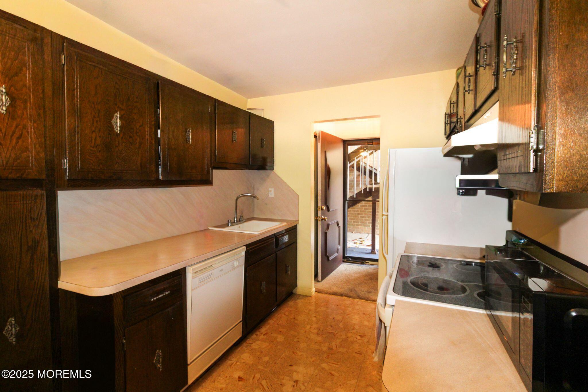 24 Meadow Green Circle, Unit A Manalapan, NJ 07726 - Photo 3 of 24 a kitchen with stainless steel appliances granite countertop a refrigerator a stove and a sink