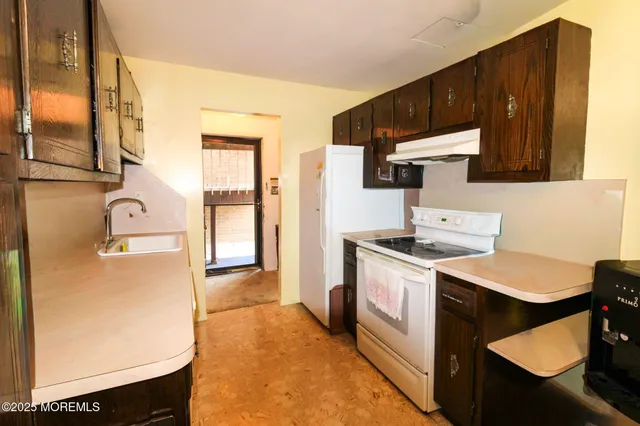 a kitchen with a sink a stove and a refrigerator