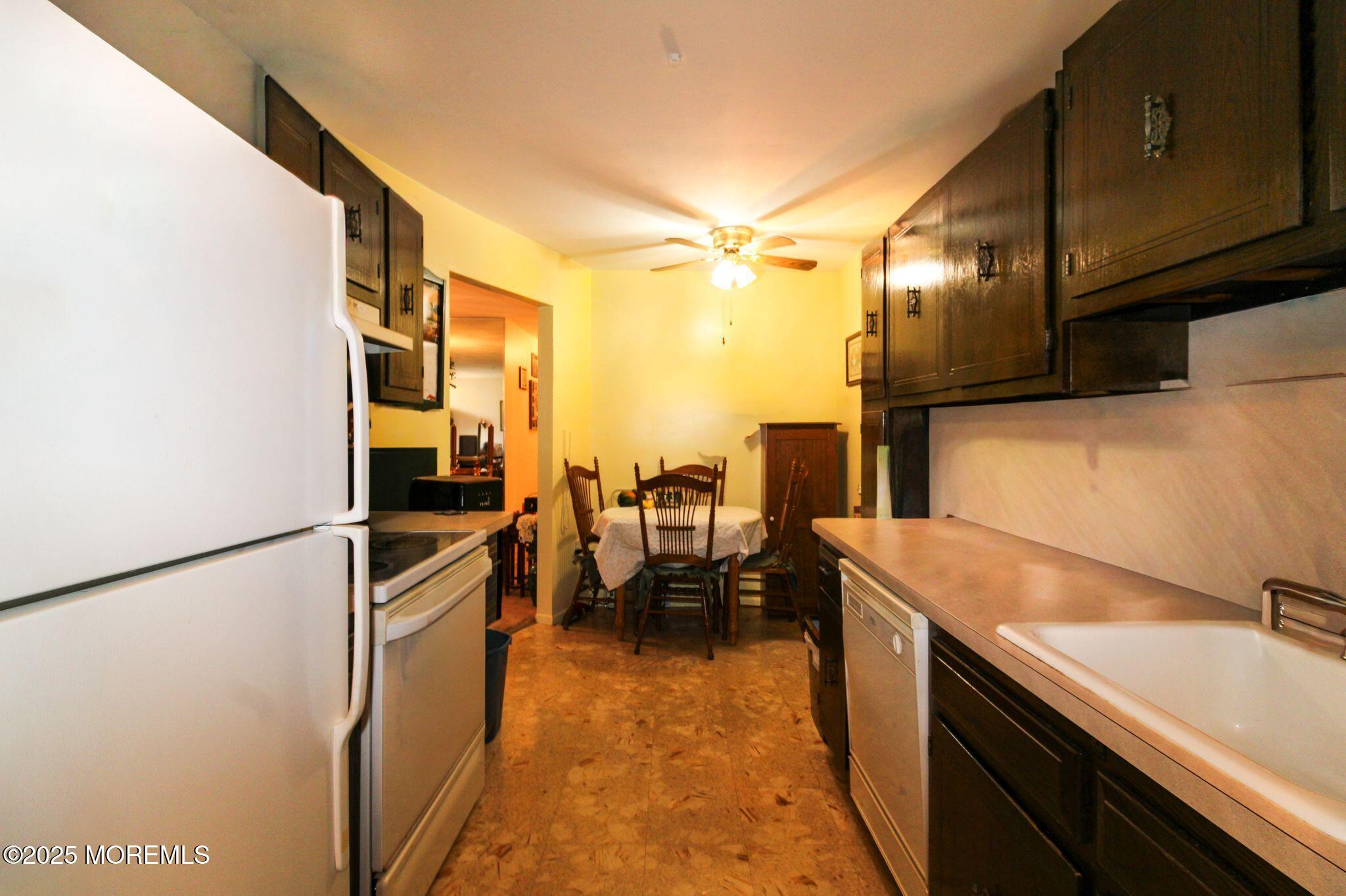 24 Meadow Green Circle, Unit A Manalapan, NJ 07726 - Photo 5 of 24 a kitchen with granite countertop a sink a stove and refrigerator