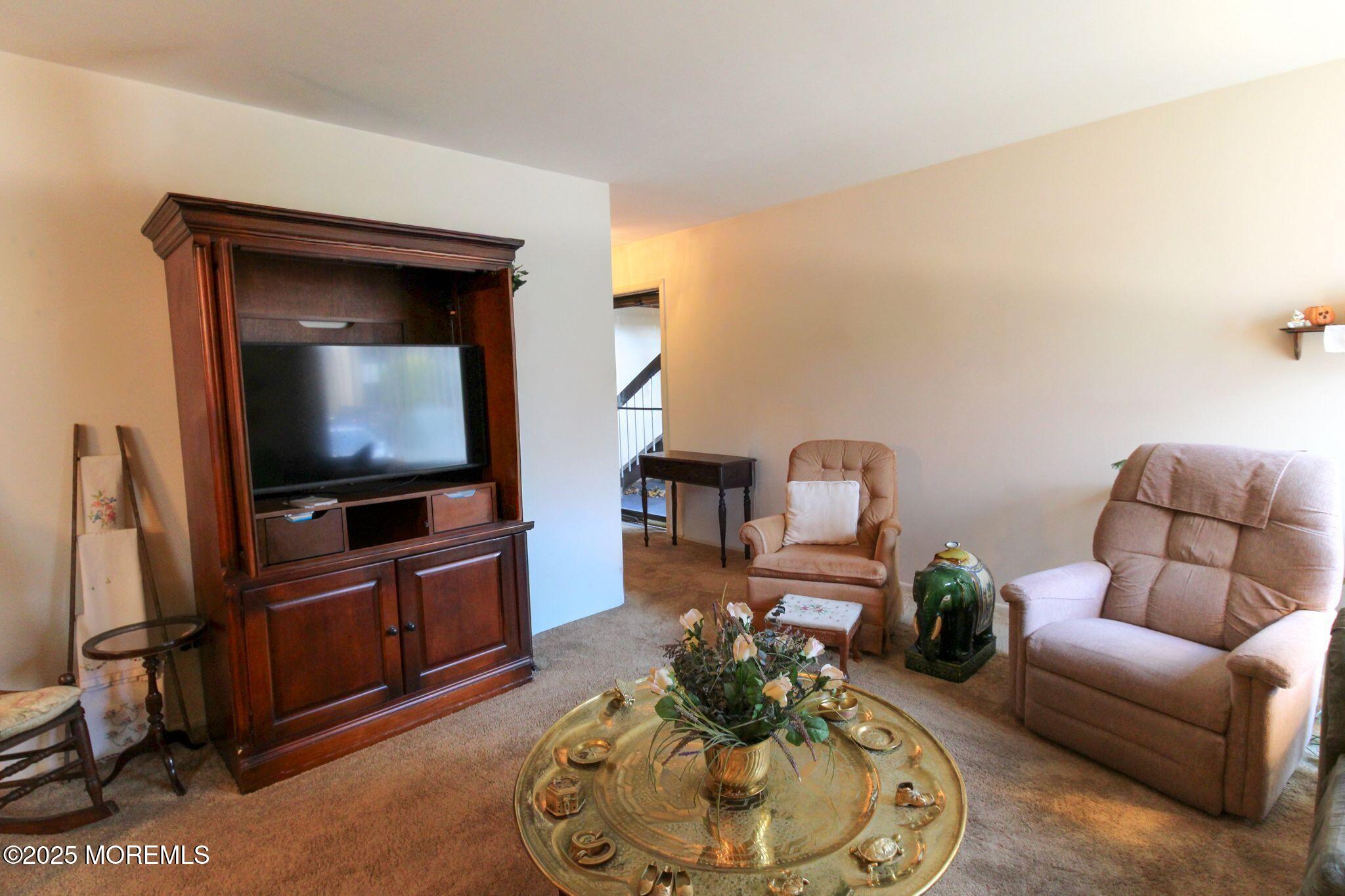 24 Meadow Green Circle, Unit A Manalapan, NJ 07726 - Photo 10 of 24 a living room with furniture and a flat screen tv