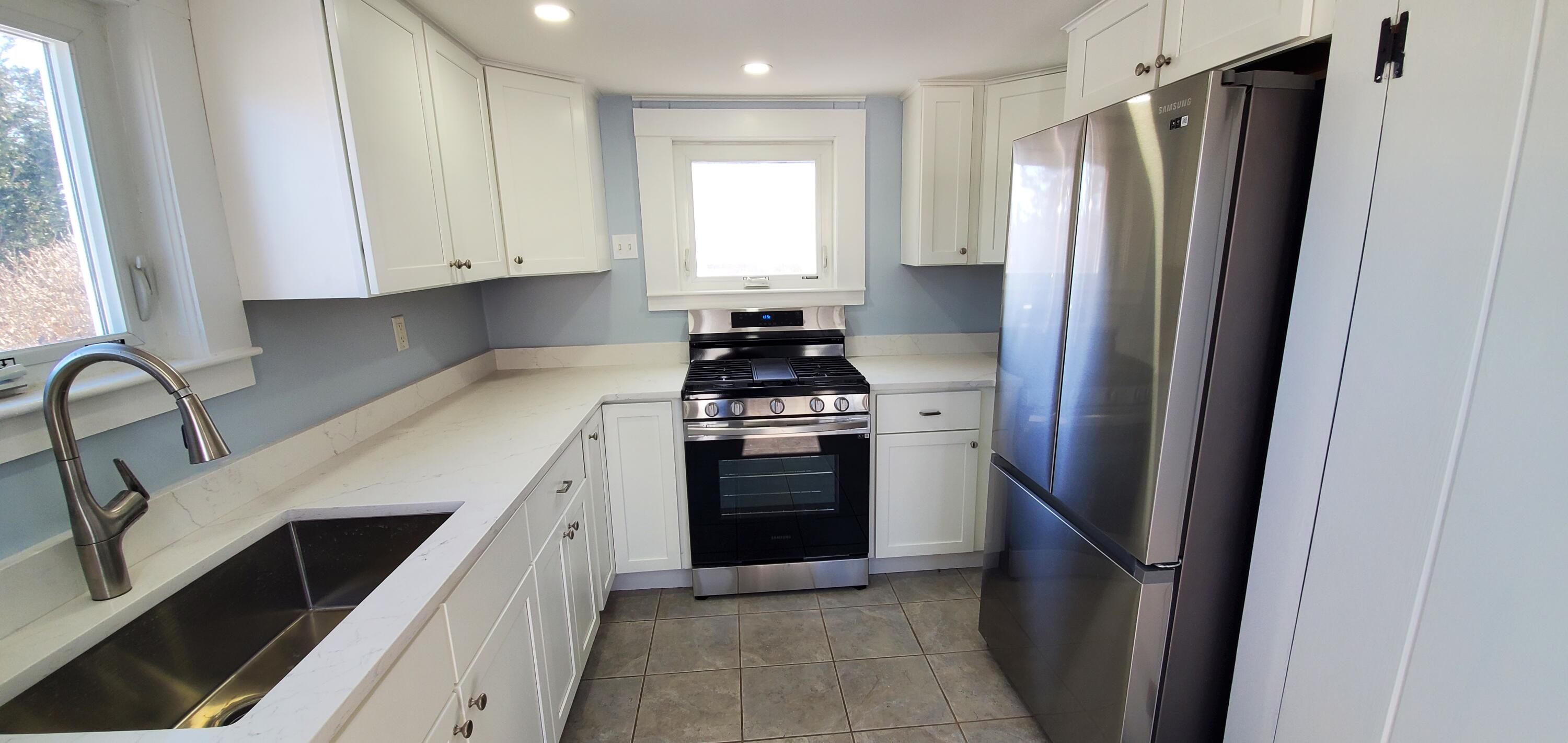 115 Seagull Road Chatham, MA 02633 - Photo 24 of 29 a kitchen with white cabinets and stainless steel appliances