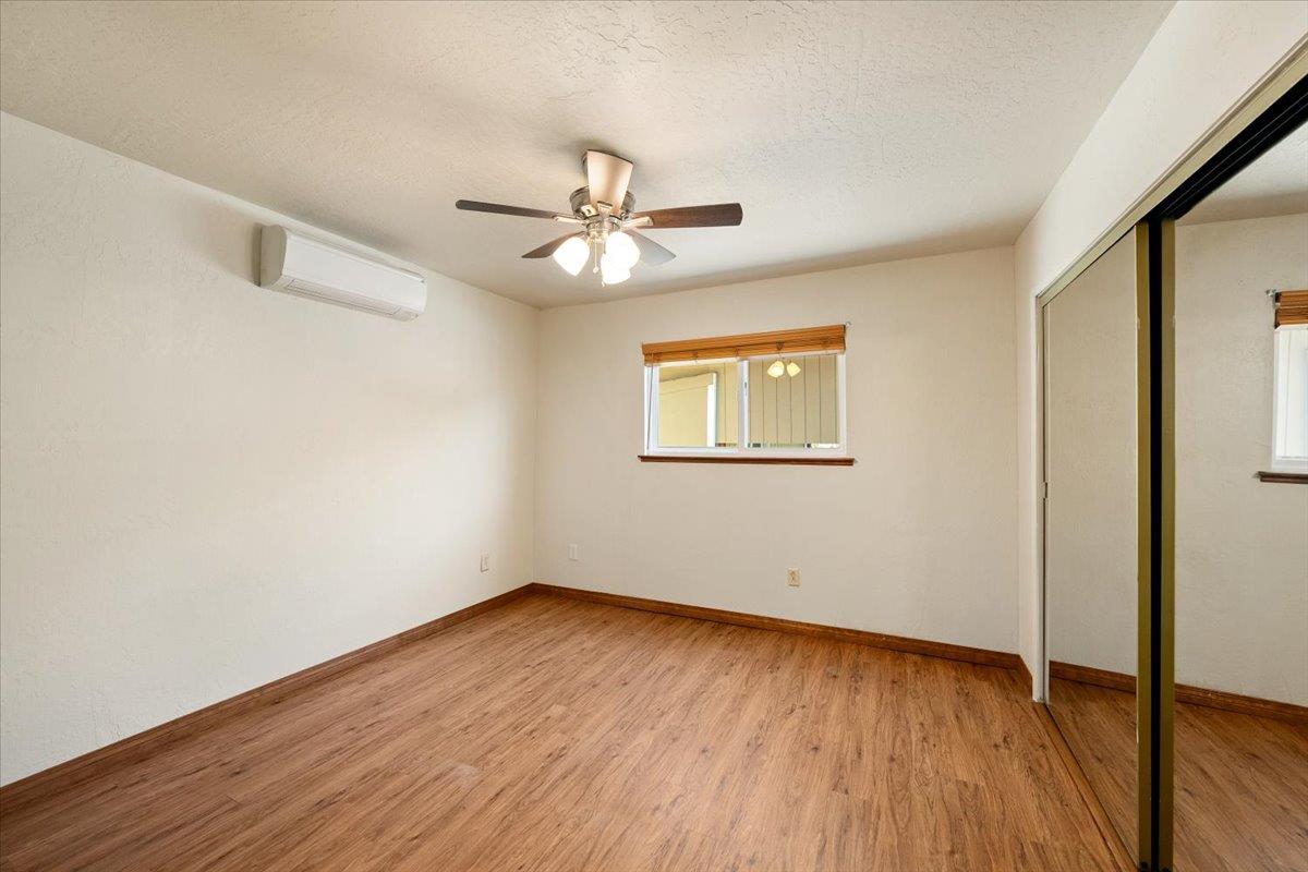1302 Nicks Lane Placerville, CA 95667 - Photo 30 of 51 an empty room with wooden floor chandelier fan and windows