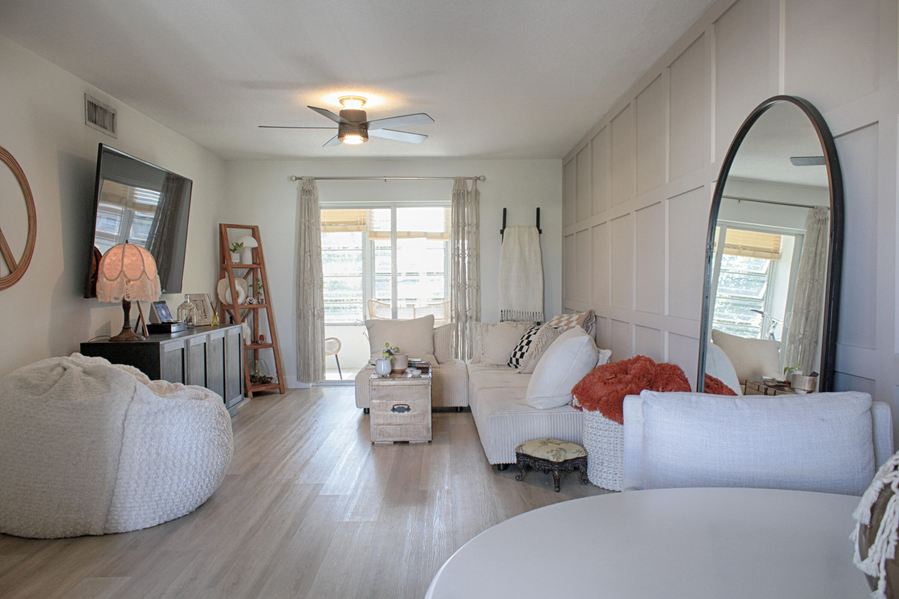 2615 Northeast 1st Court, Unit 307 Boynton Beach, FL 33435 - Photo 7 of 22 a living room with furniture and a large mirror next to a window