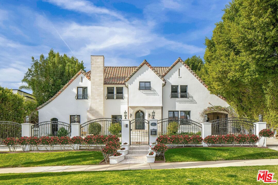 607 North Hillcrest Road Beverly Hills, CA 90210 - Photo 2 of 16 a front view of house with yard and green space