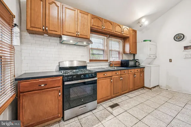 a kitchen with stainless steel appliances granite countertop a stove a sink and a microwave