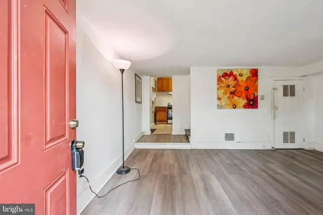 a view of empty room with wooden floor