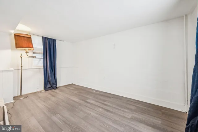 a view of a livingroom with wooden floor and a refrigerator