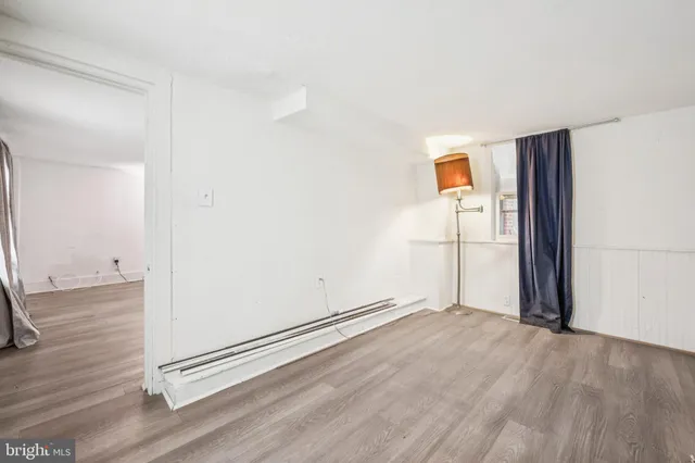 an empty room with wooden floor and a window