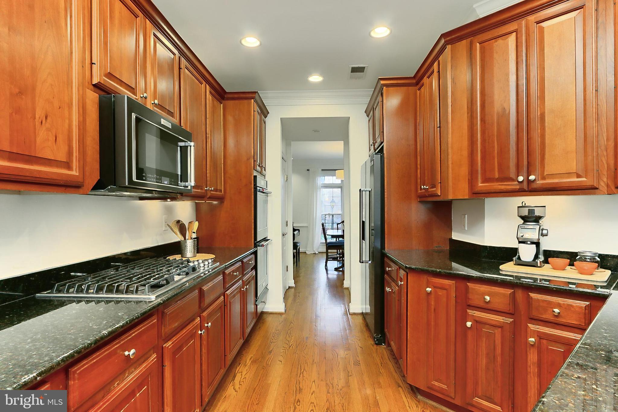132 Rees Place Falls Church, VA 22046 - Photo 18 of 66 a kitchen with stainless steel appliances granite countertop a stove a sink dishwasher and a microwave oven with cabinets