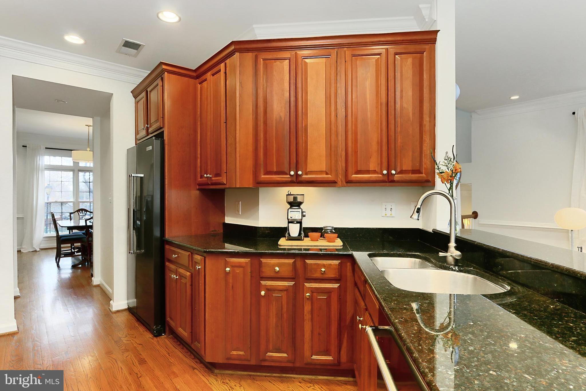 132 Rees Place Falls Church, VA 22046 - Photo 19 of 66 a kitchen with granite countertop wooden cabinets a sink a stove and wooden floor