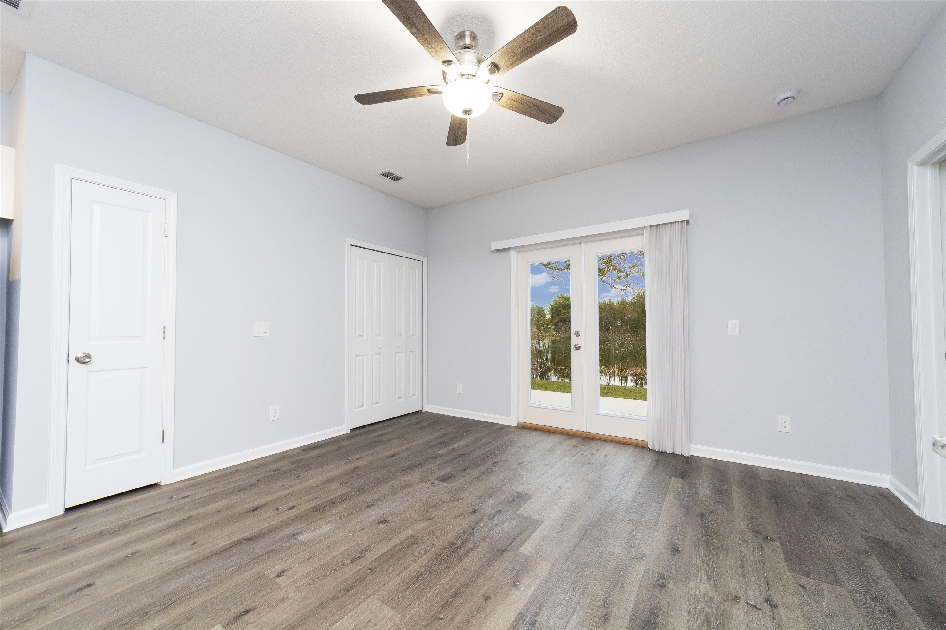 679 Coral Circle St. Augustine, FL 32080 - Photo 13 of 48 an empty room with wooden floor and windows