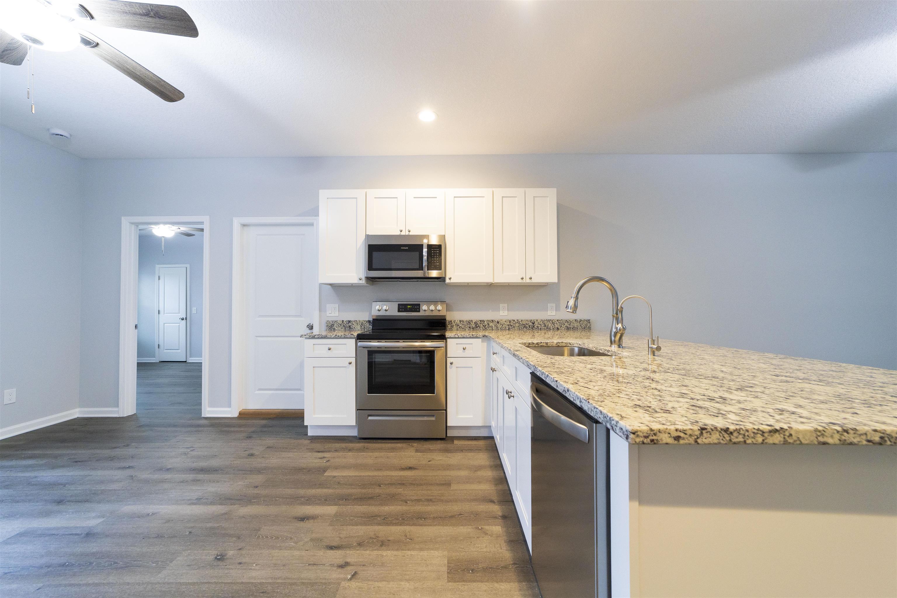 679 Coral Circle St. Augustine, FL 32080 - Photo 25 of 48 a kitchen with kitchen island granite countertop a sink cabinets and stainless steel appliances
