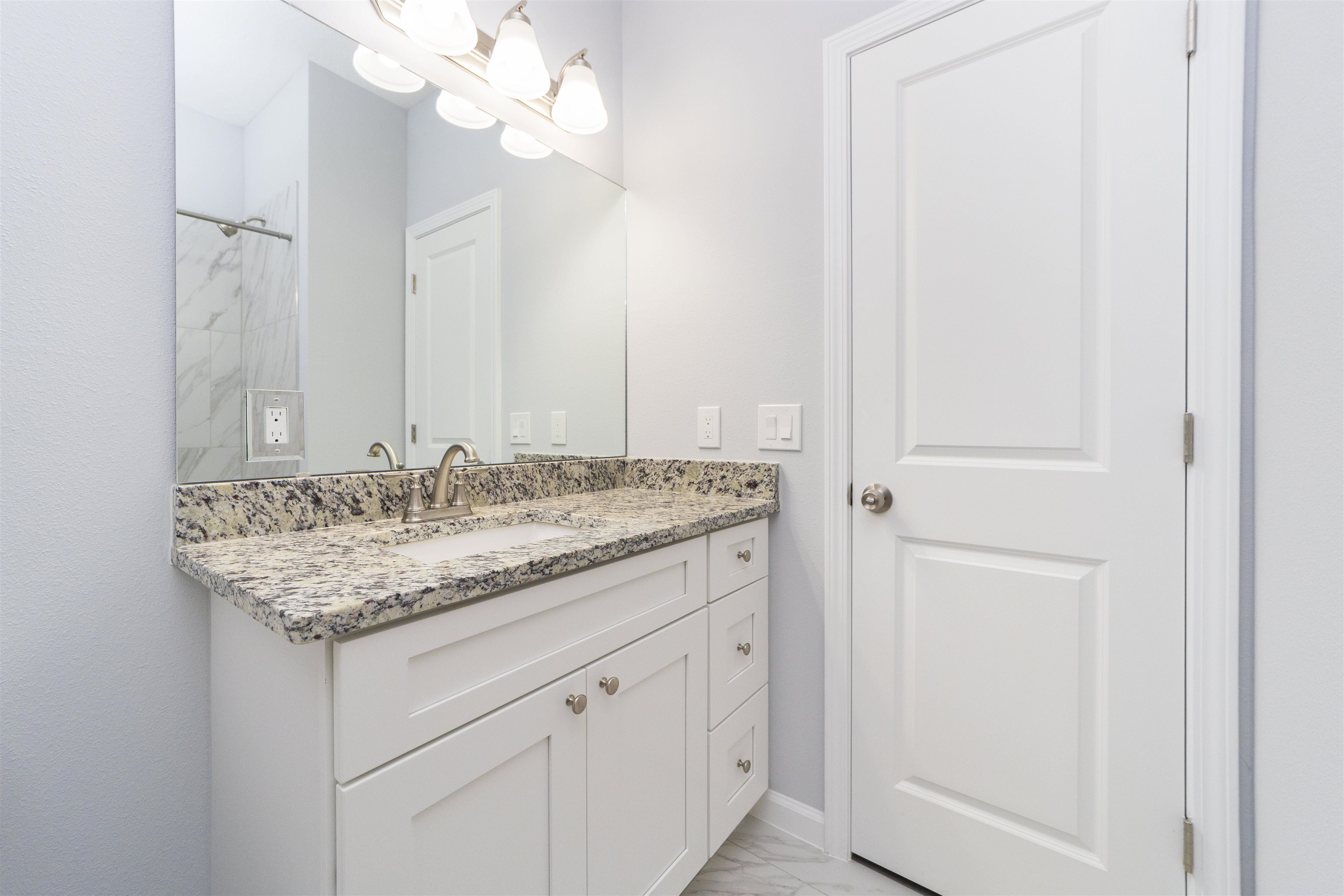 679 Coral Circle St. Augustine, FL 32080 - Photo 32 of 48 a bathroom with a granite countertop sink and a mirror