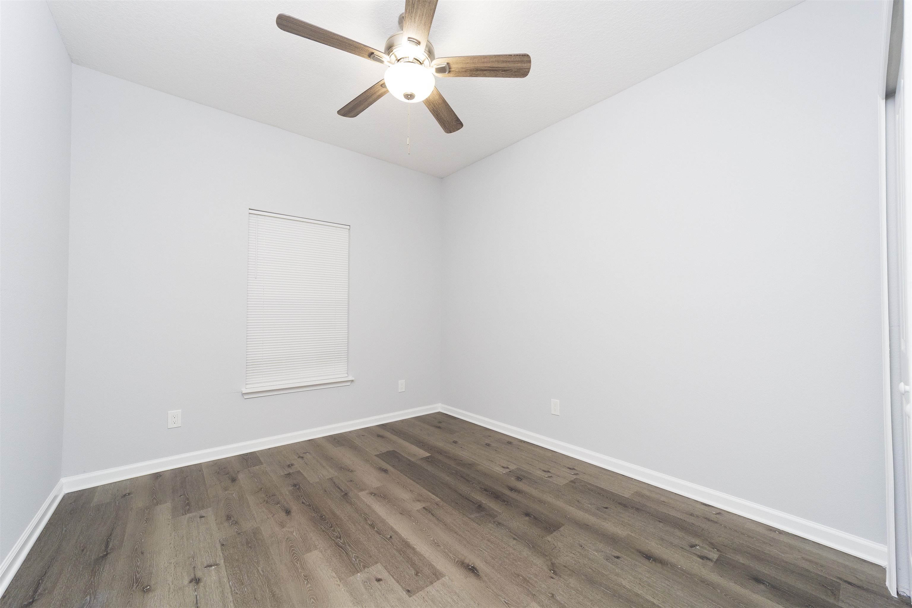 679 Coral Circle St. Augustine, FL 32080 - Photo 34 of 48 an empty room with wooden floor and fan