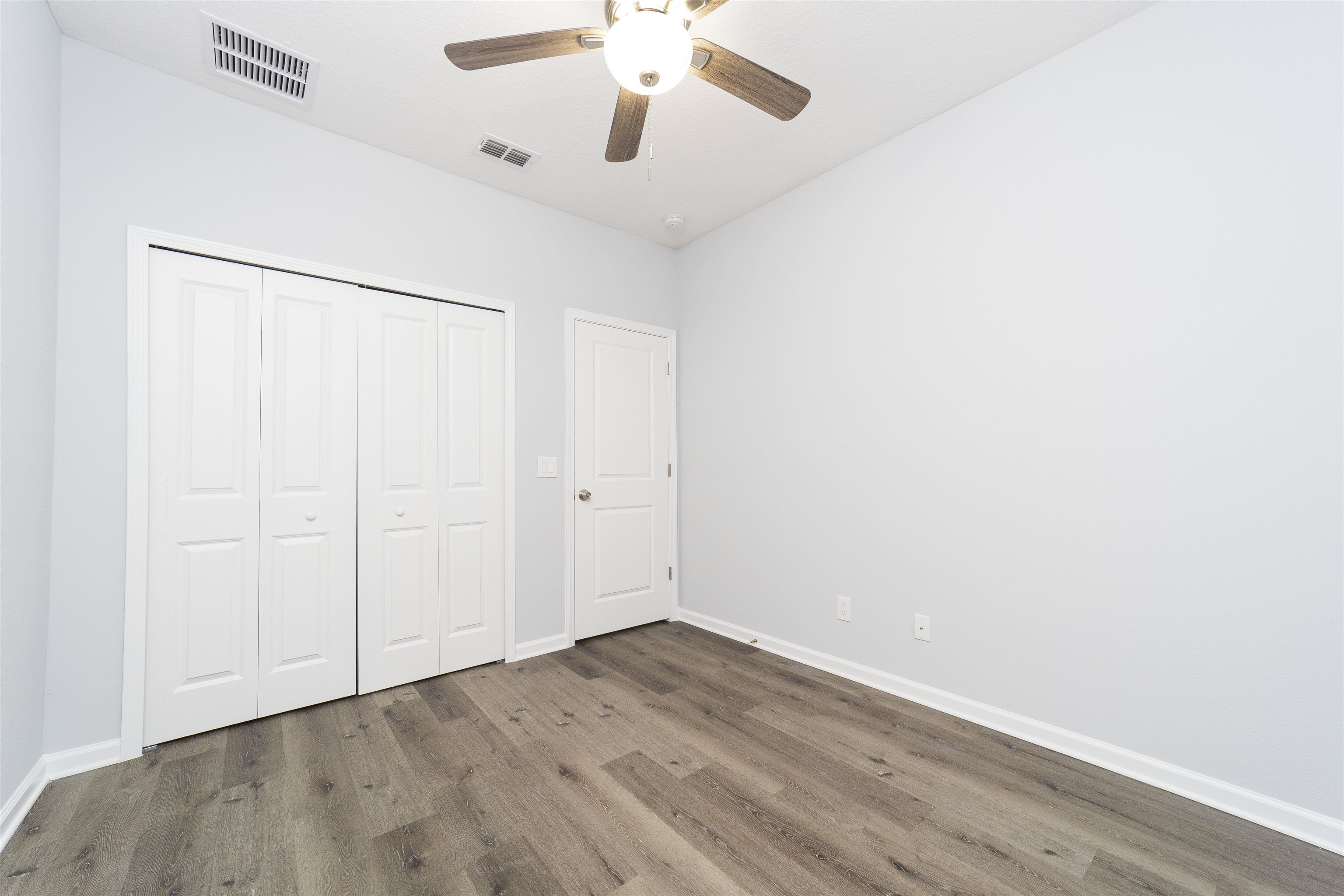 679 Coral Circle St. Augustine, FL 32080 - Photo 35 of 48 an empty room with a ceiling fan and wooden floor