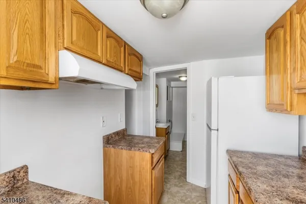 a kitchen with stainless steel appliances granite countertop a refrigerator and a stove