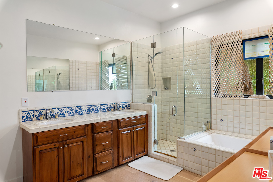 21424 Deerpath Lane Malibu, CA 90265 - Photo 33 of 51 a bathroom with a sink a mirror and a shower