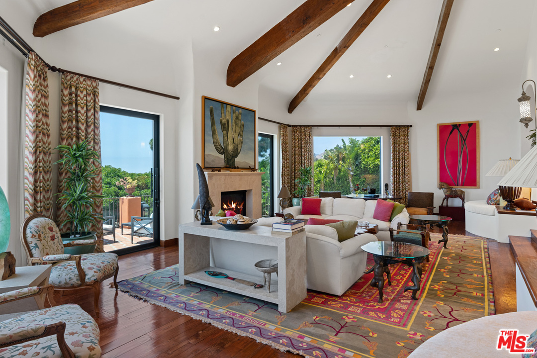 21424 Deerpath Lane Malibu, CA 90265 - Photo 9 of 51 a living room with furniture fireplace and a large window