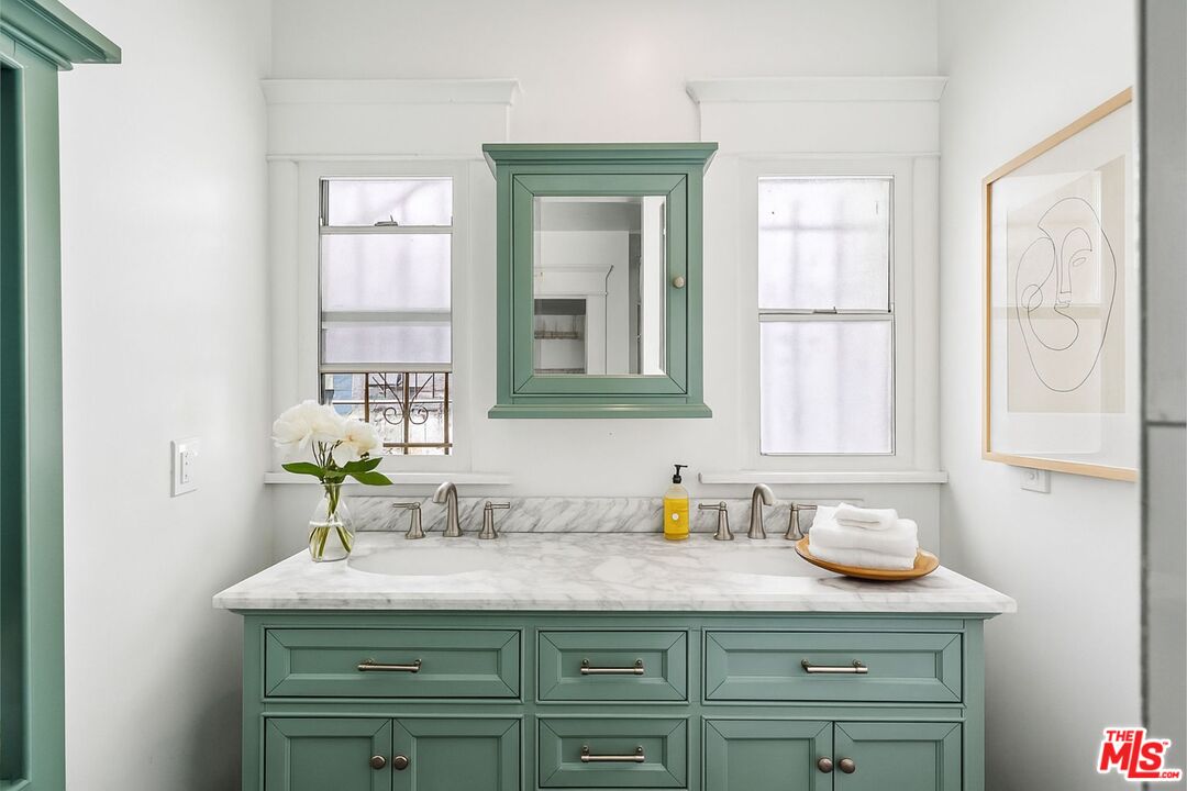 5342 Lemon Grove Avenue Los Angeles, CA 90038 - Photo 12 of 30 a bathroom with a granite countertop sink and a mirror