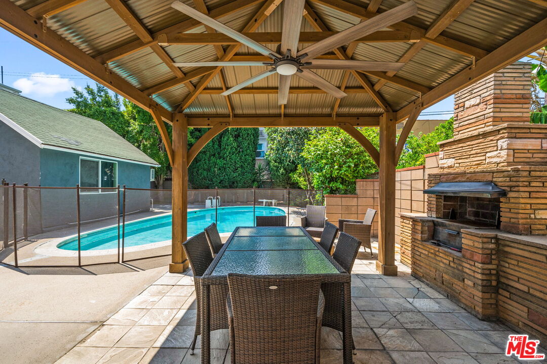 5342 Lemon Grove Avenue Los Angeles, CA 90038 - Photo 3 of 30 a view of a patio with a table and chairs under an umbrella with a small yard
