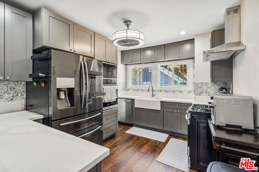 5342 Lemon Grove Avenue Los Angeles, CA 90038 - Photo 8 of 30 a kitchen with stainless steel appliances a stove a sink and a refrigerator