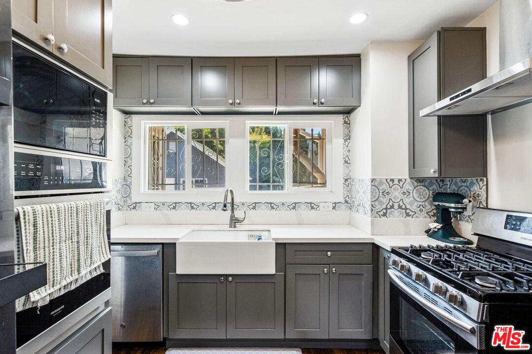 5342 Lemon Grove Avenue Los Angeles, CA 90038 - Photo 9 of 30 a kitchen with stainless steel appliances a sink stove and cabinets