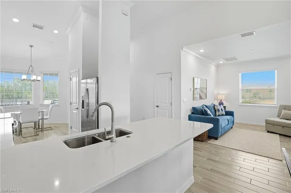 a kitchen with stainless steel appliances kitchen island granite countertop a sink and white cabinets