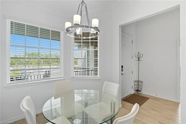 a dining room with furniture a chandelier and wooden floor
