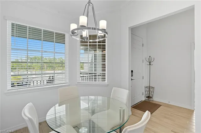 a dining room with furniture a chandelier and wooden floor