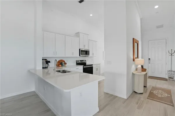 a white kitchen with a sink a refrigerator and a stove