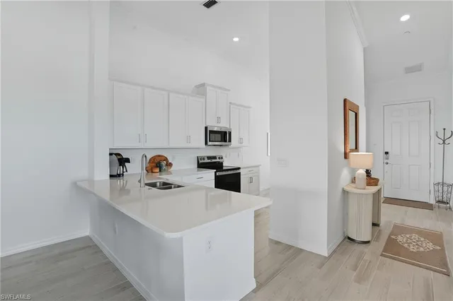 a white kitchen with a sink a refrigerator and a stove
