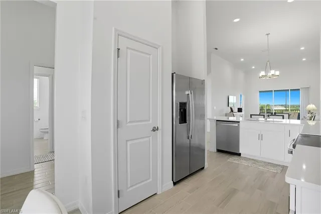 a kitchen with white cabinets and refrigerator
