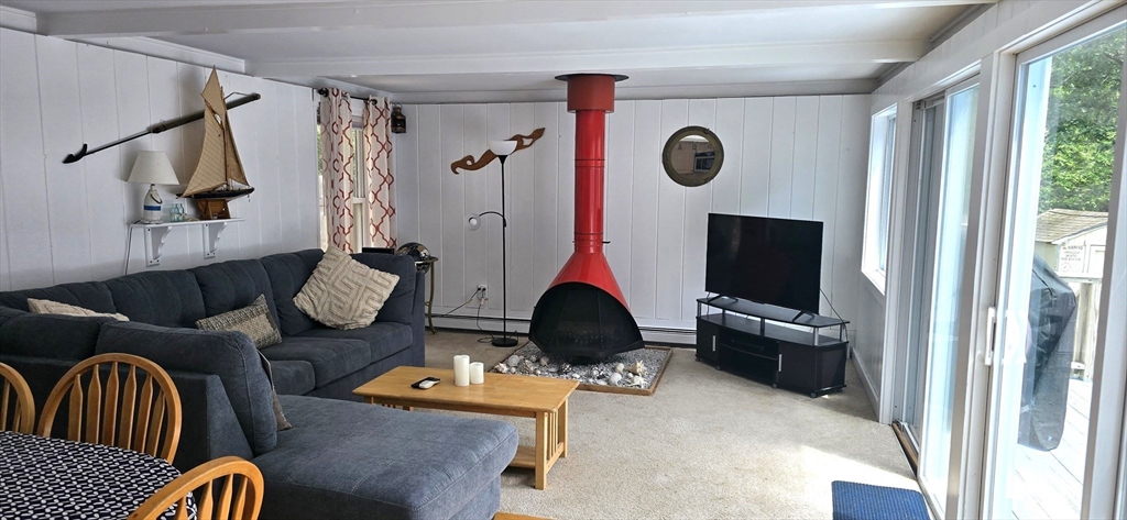 35 Tecumseh Road Wellfleet, MA 02667 - Photo 8 of 24 a living room with furniture a flat screen tv and a floor to ceiling window
