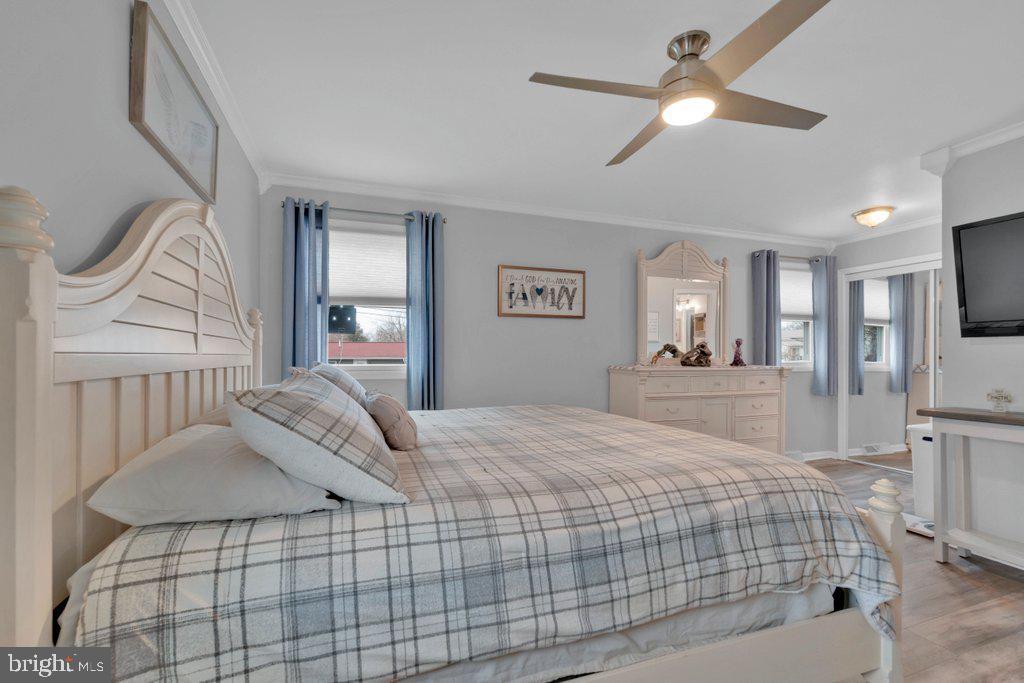 714 Joppa Farm Road Joppa, MD 21085 - Photo 26 of 46 a bedroom with a bed a mirror on dresser and a chandelier