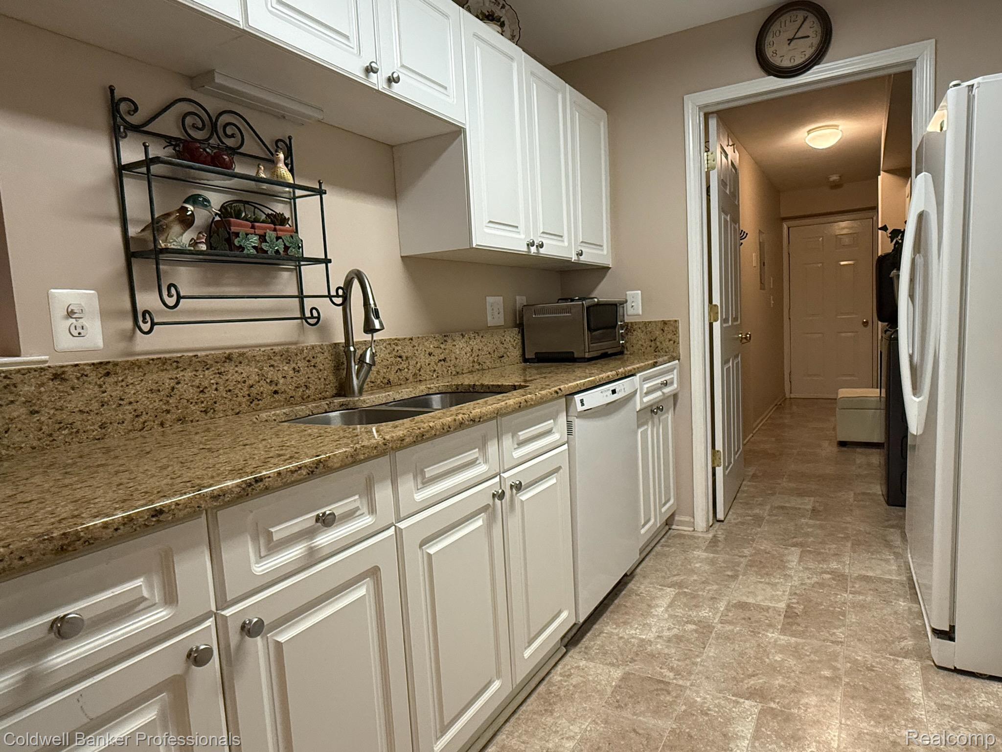 5349 Brookemonte Circle Rochester, MI 48306 - Photo 26 of 45 Kitchen featuring white appliances, white cabinets, stone finish flooring, and dark stone counters