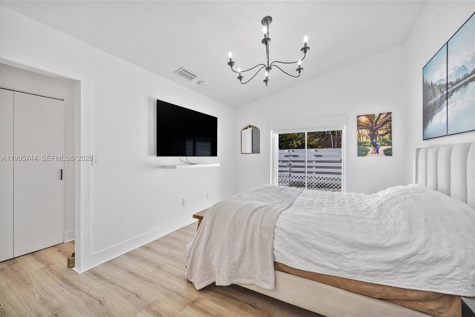 14720 Southwest 139th Avenue, Unit 139 Miami, FL 33186 - Photo 16 of 34 a bedroom with a bed a tv and wooden floor
