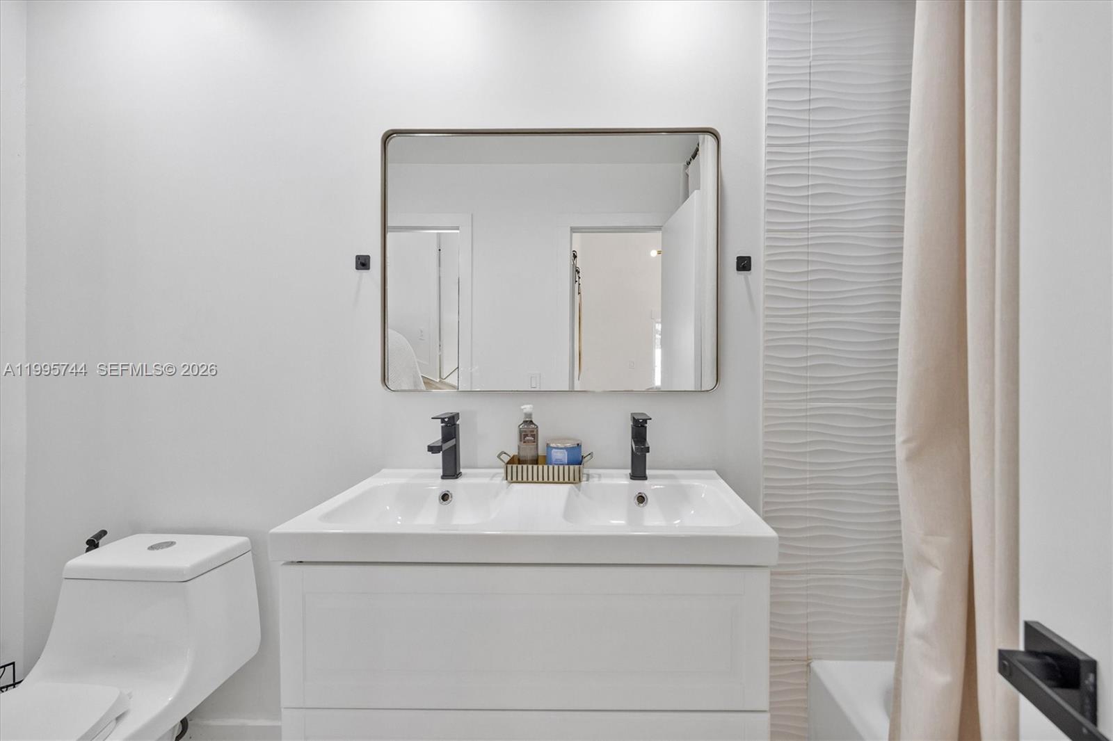 14720 Southwest 139th Avenue, Unit 139 Miami, FL 33186 - Photo 19 of 34 a bathroom with a sink a toilet and mirror