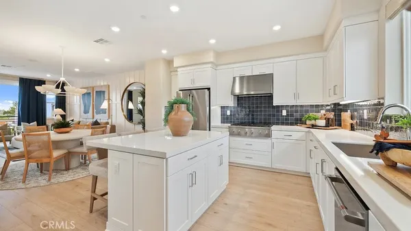 a kitchen with a sink white cabinets and stainless steel appliances