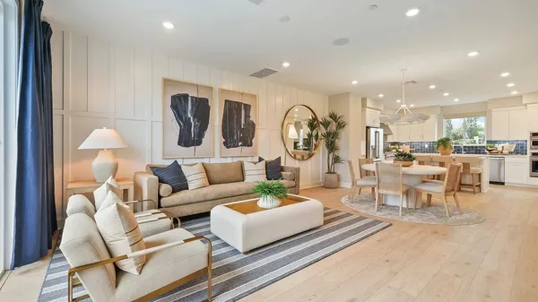 a living room with furniture and a view of kitchen