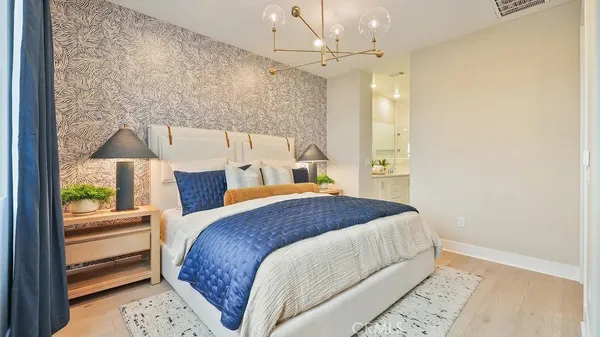 a bedroom with a bed a mirror and lamp